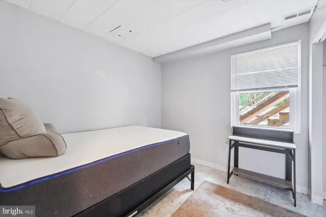 a bedroom with a bed and a window