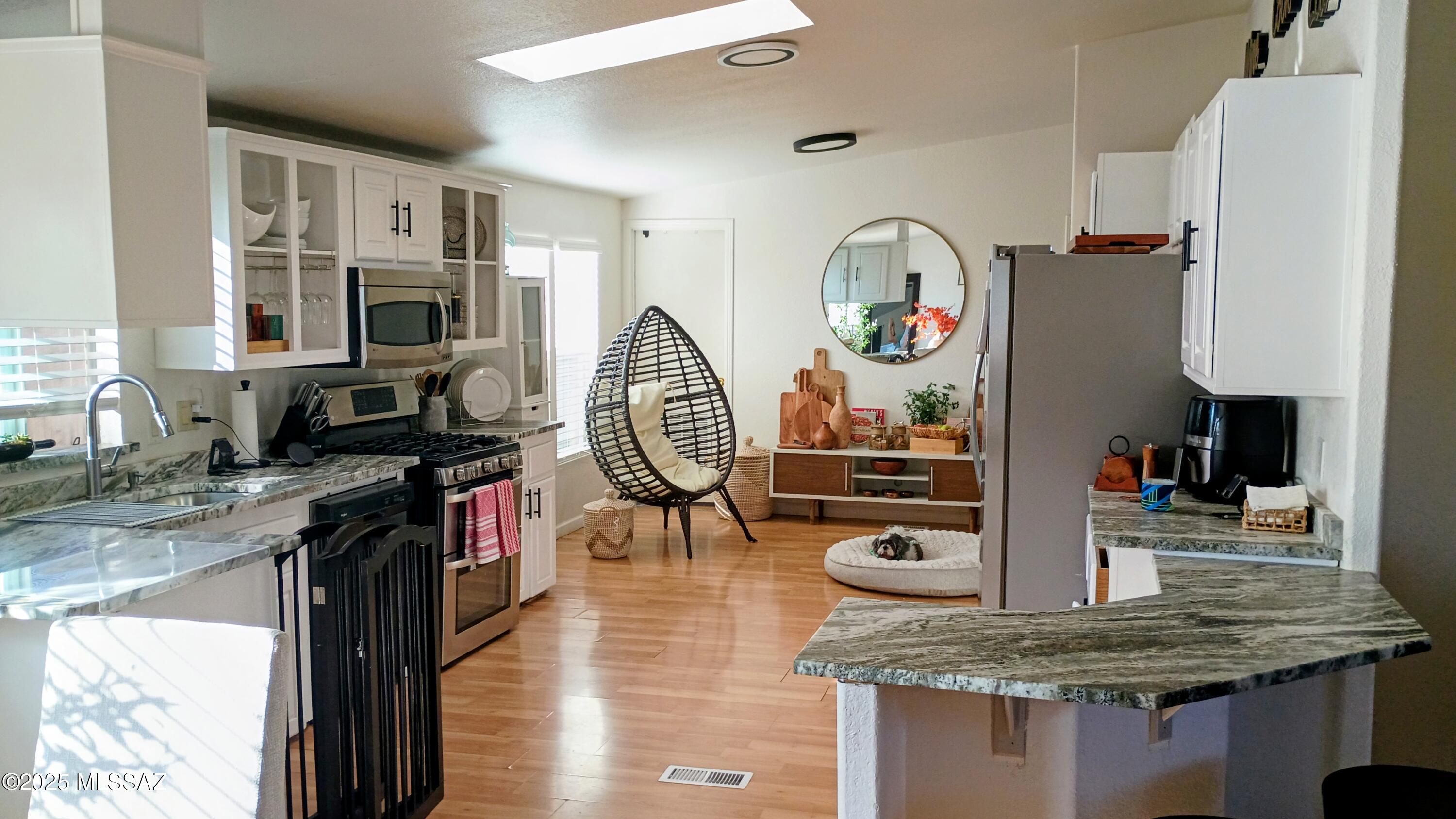 1449 West Hualpai Road Tucson, AZ 85745 - Photo 13 of 49 a kitchen with stainless steel appliances granite countertop a sink dishwasher stove and refrigerator with wooden floor
