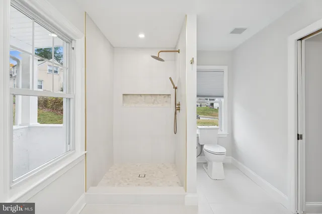 a bathroom with a granite countertop shower a toilet and a shower