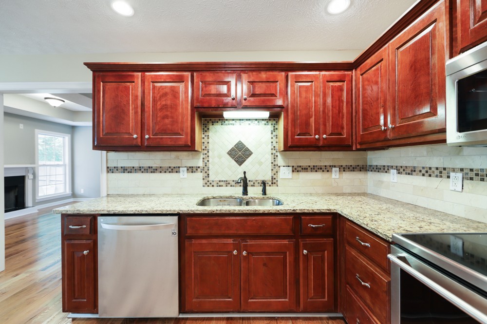 323 Independence Street Springfield, TN 37172 - Photo 13 of 37 a kitchen with granite countertop stainless steel appliances a stove sink and cabinets