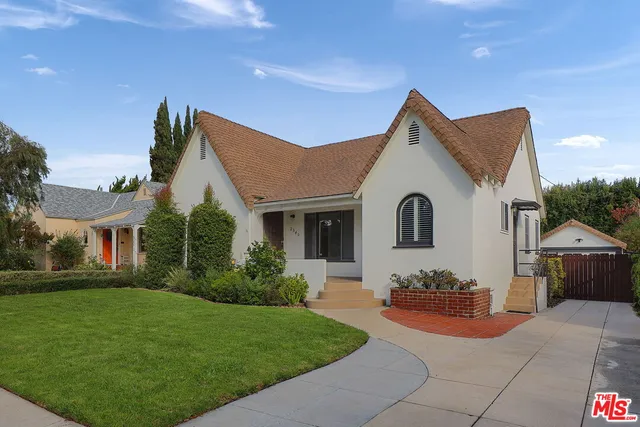 a front view of a house with a garden and plants