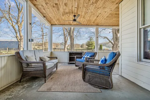 a roof deck with table and chairs and potted plants
