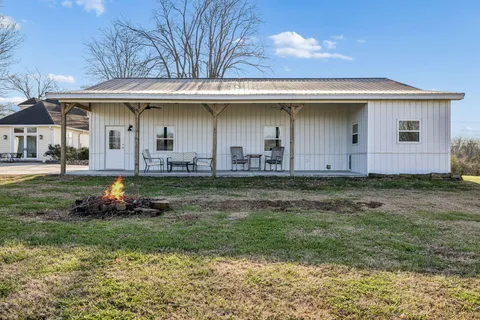 a view of a large pool with lawn chairs under an umbrella