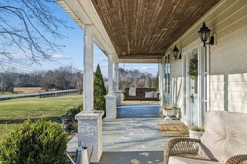 a view of a porch with furniture and garden