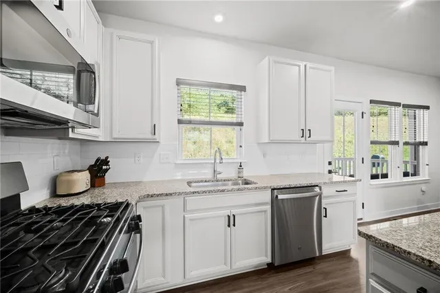 a kitchen with a sink stove top oven and cabinets