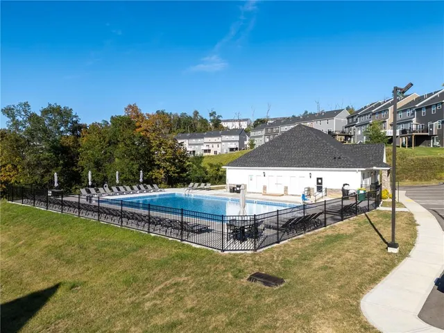 a view of a swimming pool with lawn chairs and plants