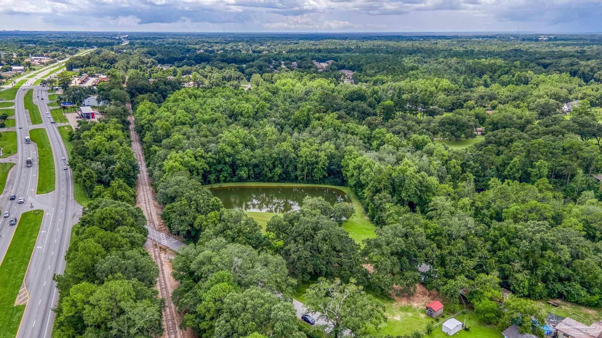 2345 Pompano Street Cantonment, FL 32533 - Photo 18 of 48 a view of a lush green forest with a house