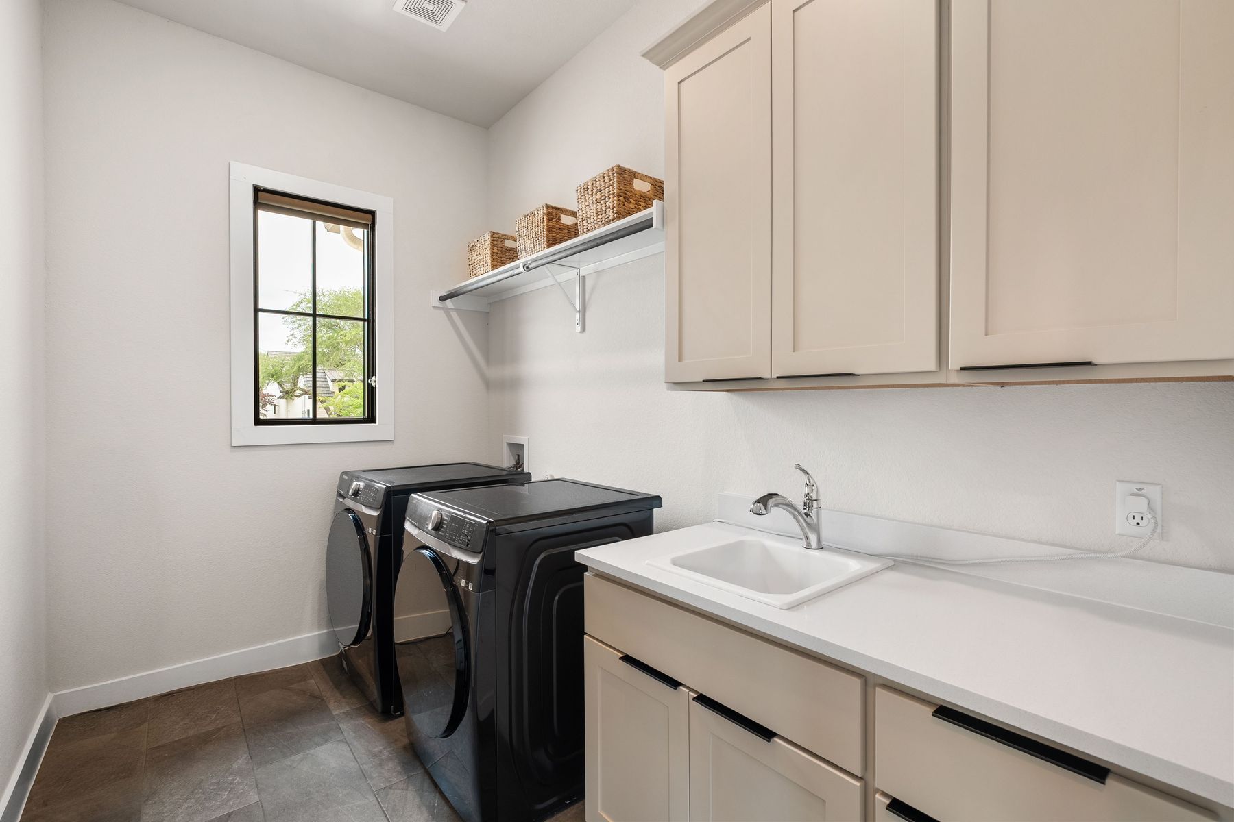 1106 Flint Ridge Trail Georgetown, TX 78628 - Photo 10 of 38 Functional laundry space featuring modern appliances, ample storage, and a convenient utility sink.