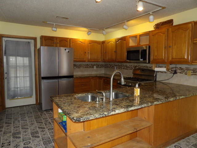 180 Morris Road Galatia, IL 62935 - Photo 13 of 28 a kitchen with kitchen island granite countertop a sink a counter top space cabinets and stainless steel appliances