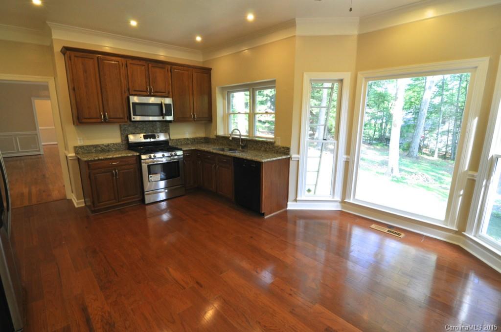 5015 Ridgetop Trail Charlotte, NC 28215 - Photo 12 of 24 a large kitchen with stainless steel appliances granite countertop a stove a sink a refrigerator with wooden cabinets and wooden floor