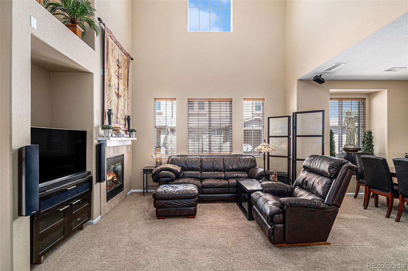 10515 Ashfield Street, Unit 1D Highlands Ranch, CO 80126 - Photo 11 of 39 a living room with furniture a flat screen tv and a floor to ceiling window