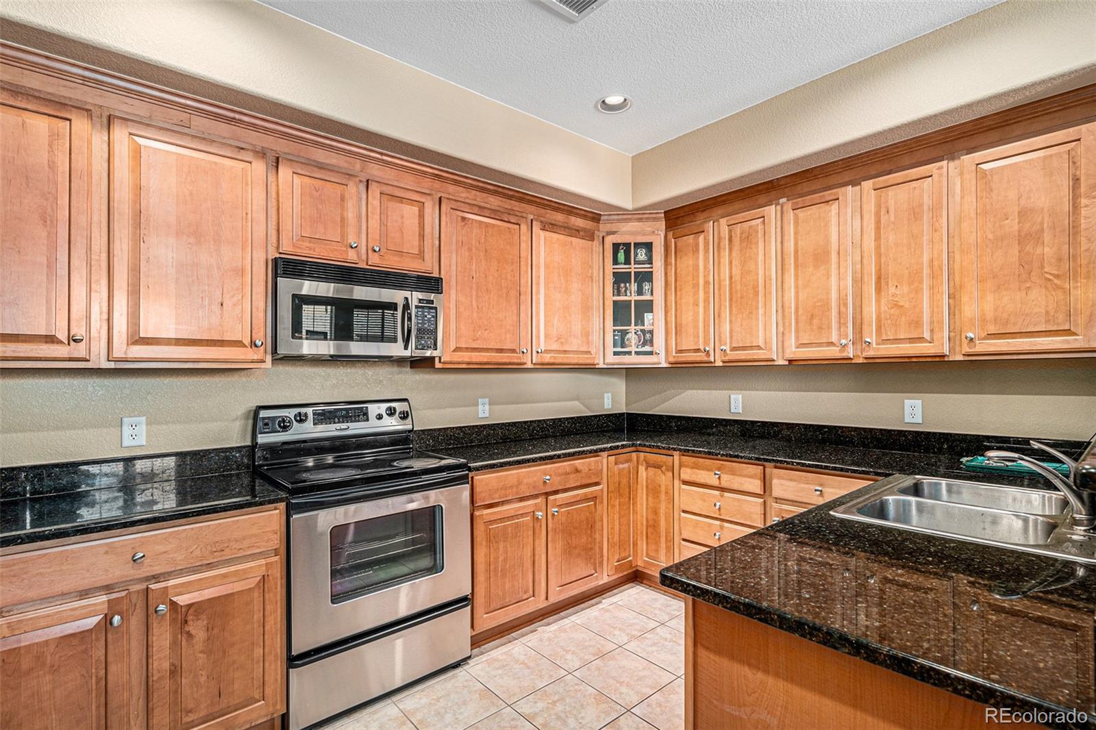 10515 Ashfield Street, Unit 1D Highlands Ranch, CO 80126 - Photo 17 of 39 a kitchen with granite countertop a stove sink and cabinets