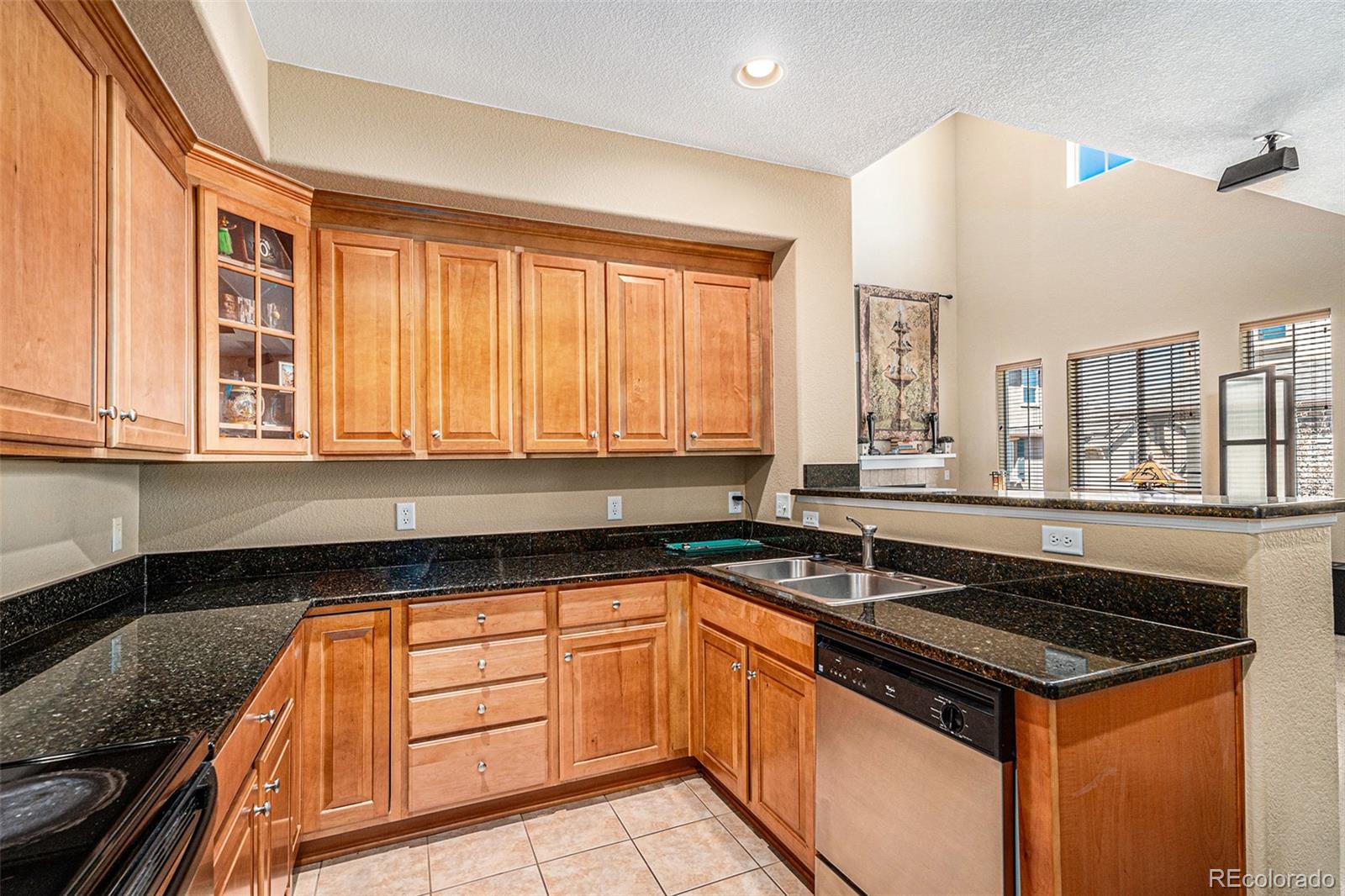 10515 Ashfield Street, Unit 1D Highlands Ranch, CO 80126 - Photo 18 of 39 a kitchen with granite countertop a sink stove and cabinets