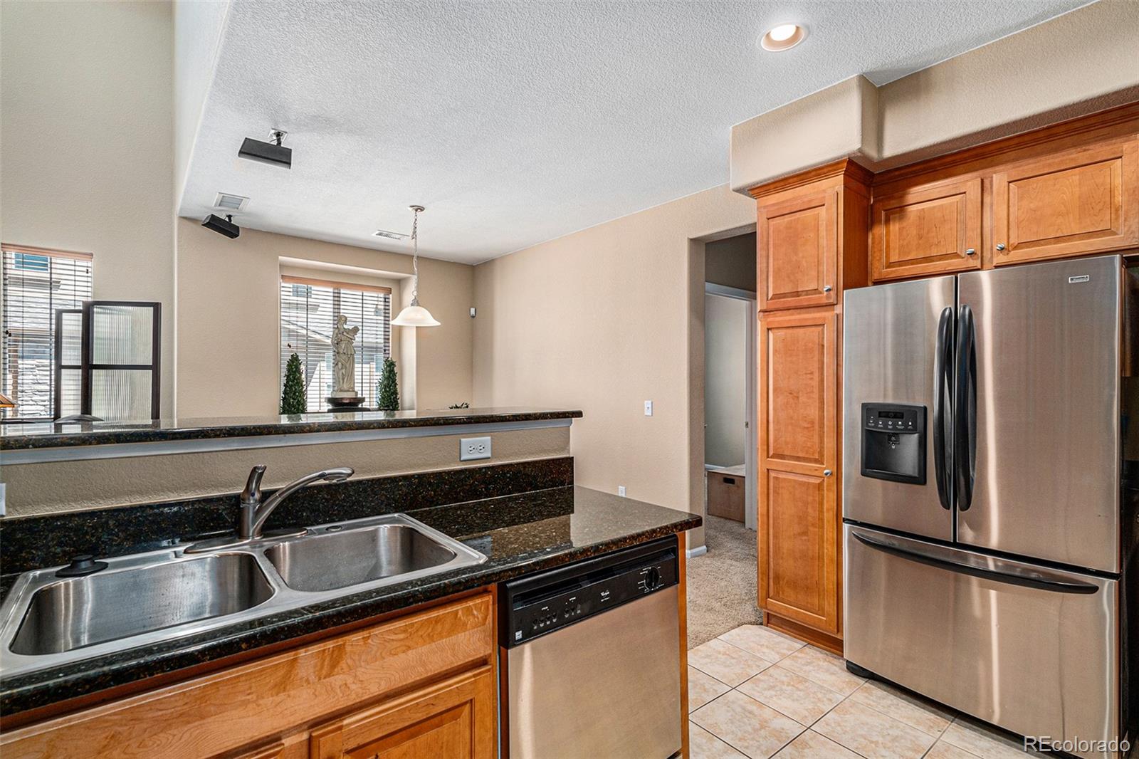 10515 Ashfield Street, Unit 1D Highlands Ranch, CO 80126 - Photo 21 of 39 a kitchen with stainless steel appliances granite countertop a refrigerator and a sink