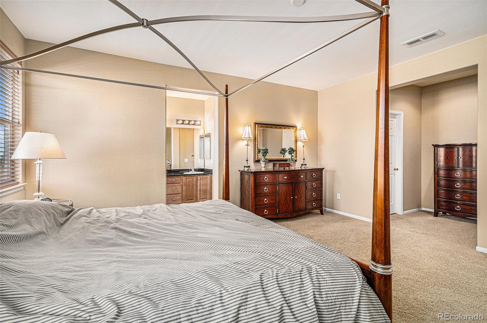 10515 Ashfield Street, Unit 1D Highlands Ranch, CO 80126 - Photo 31 of 39 a bedroom with a bed and a view of bathroom