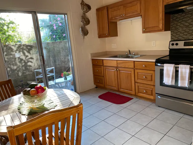 a kitchen with a sink a stove and wooden floor