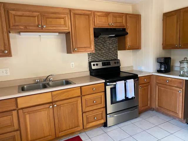 a kitchen with stainless steel appliances granite countertop a sink stove and cabinets