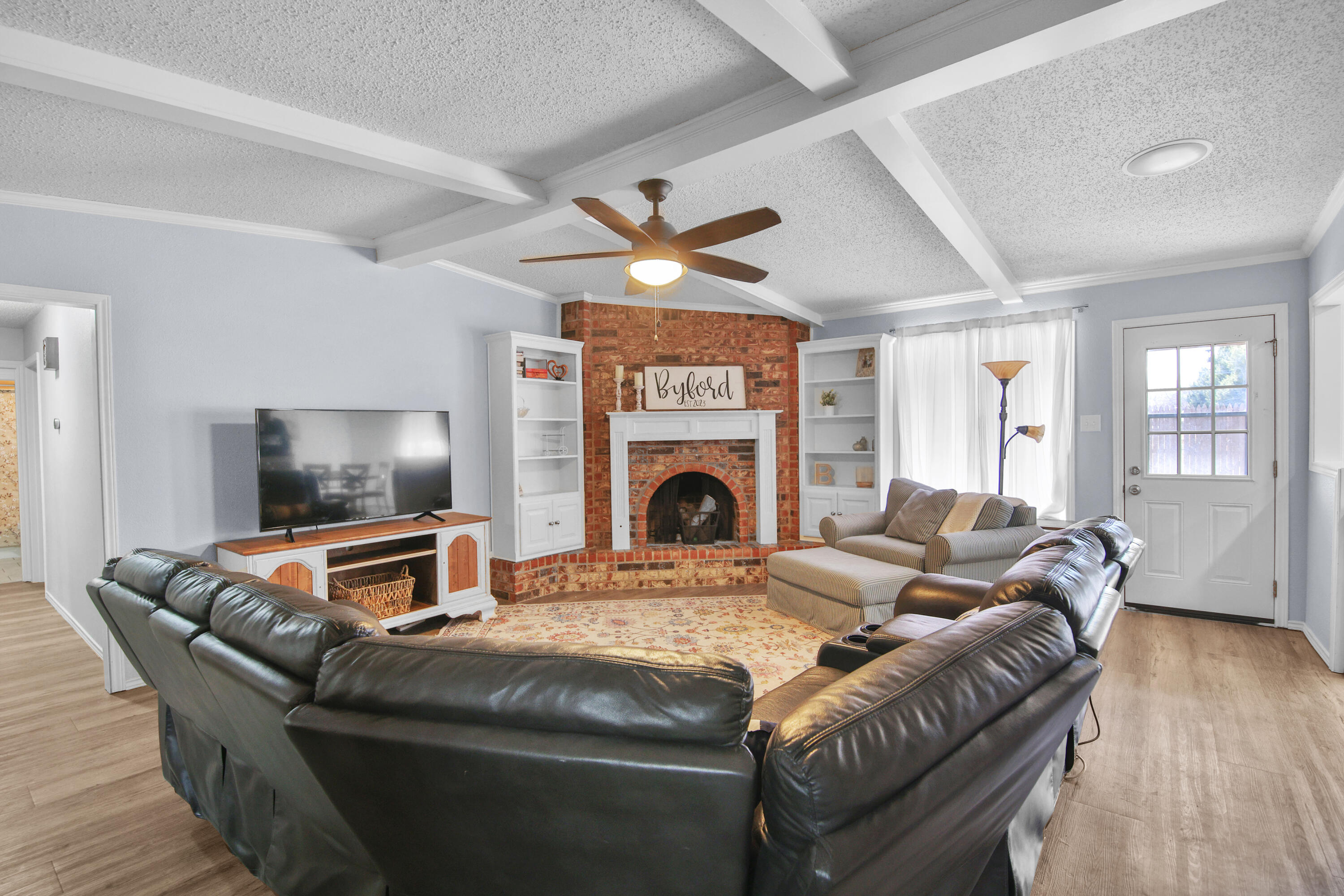 4805 73rd Street Lubbock, TX 79424 - Photo 7 of 26 a living room with furniture a fireplace and a flat screen tv