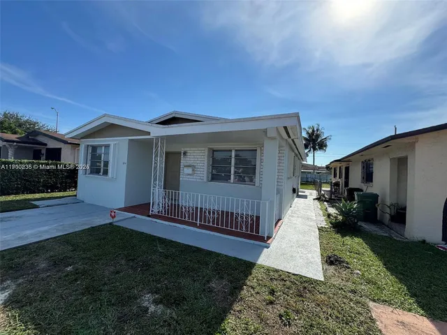 a front view of a house with a yard and outdoor seating