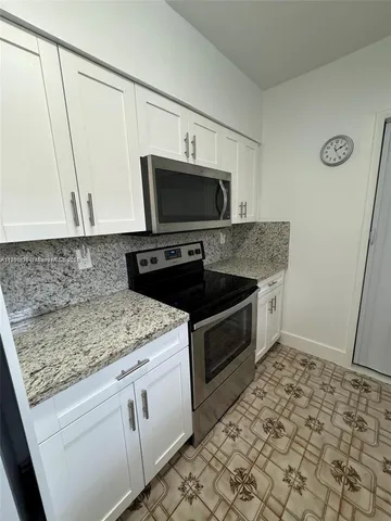 a kitchen with stainless steel appliances granite countertop a sink stove and microwave