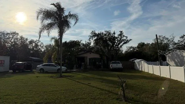 a front view of a house with garden and trees