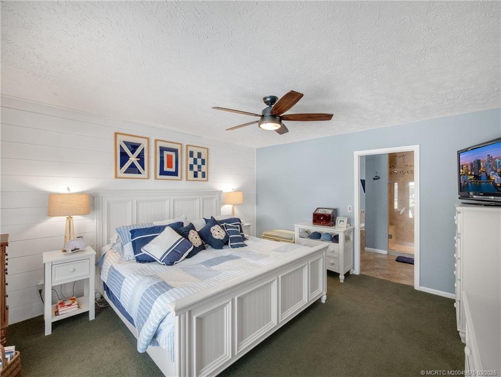 1318 Southeast Riverside Drive Stuart, FL 34996 - Photo 16 of 29 a bed room with a bed and a chandelier