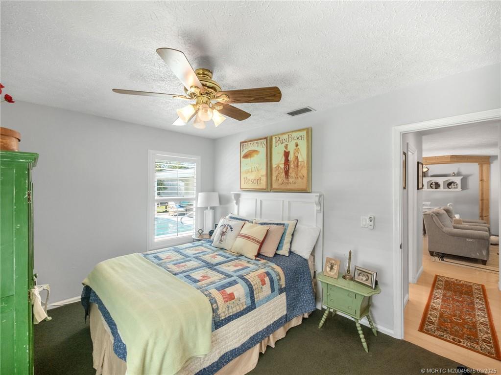1318 Southeast Riverside Drive Stuart, FL 34996 - Photo 19 of 29 a bedroom with a bed and a chandelier