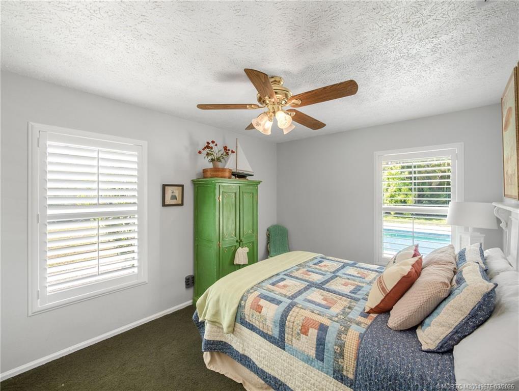 1318 Southeast Riverside Drive Stuart, FL 34996 - Photo 20 of 29 a bedroom with a bed and a large window