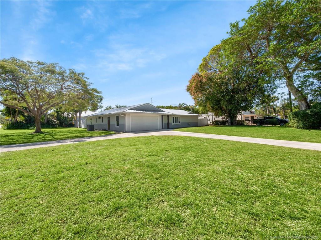 1318 Southeast Riverside Drive Stuart, FL 34996 - Photo 2 of 29 a view of a house with a big yard