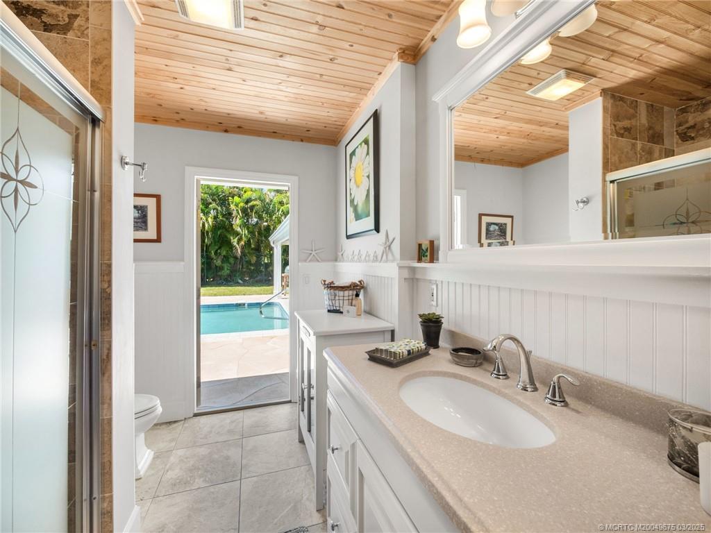 1318 Southeast Riverside Drive Stuart, FL 34996 - Photo 22 of 29 a bathroom with a sink vanity granite tub shower and a mirror
