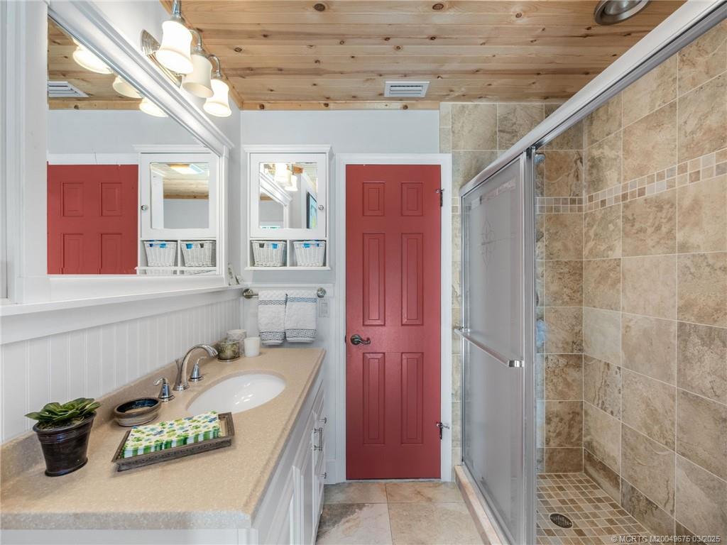 1318 Southeast Riverside Drive Stuart, FL 34996 - Photo 23 of 29 a bathroom with a granite countertop sink a mirror and shower