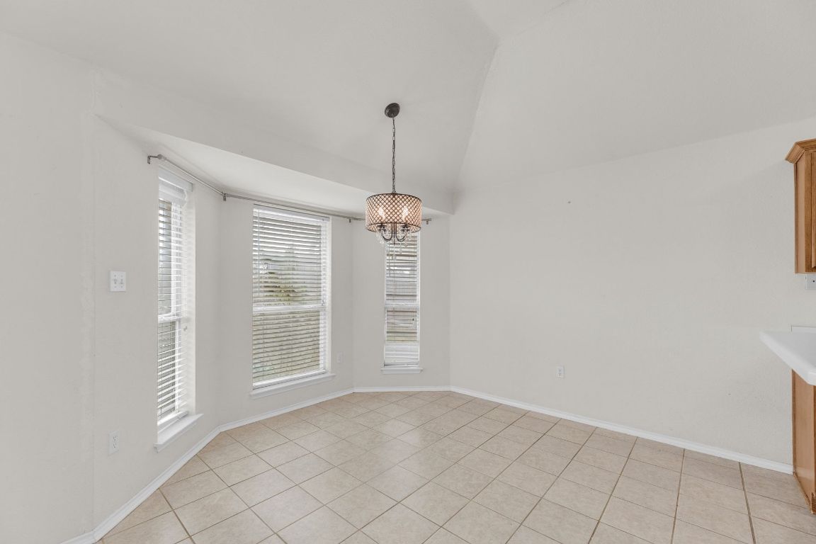 2317 Chestnut Path Round Rock, TX 78664 - Photo 17 of 36 Unfurnished dining area with lofted ceiling, light tile patterned floors, and a chandelier