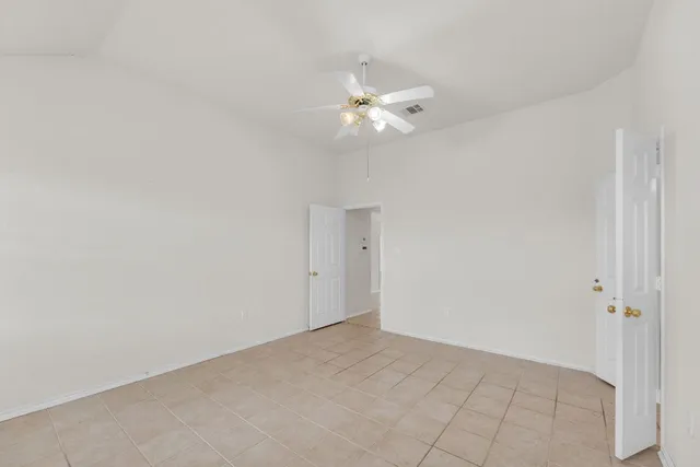 an empty room with windows and fan