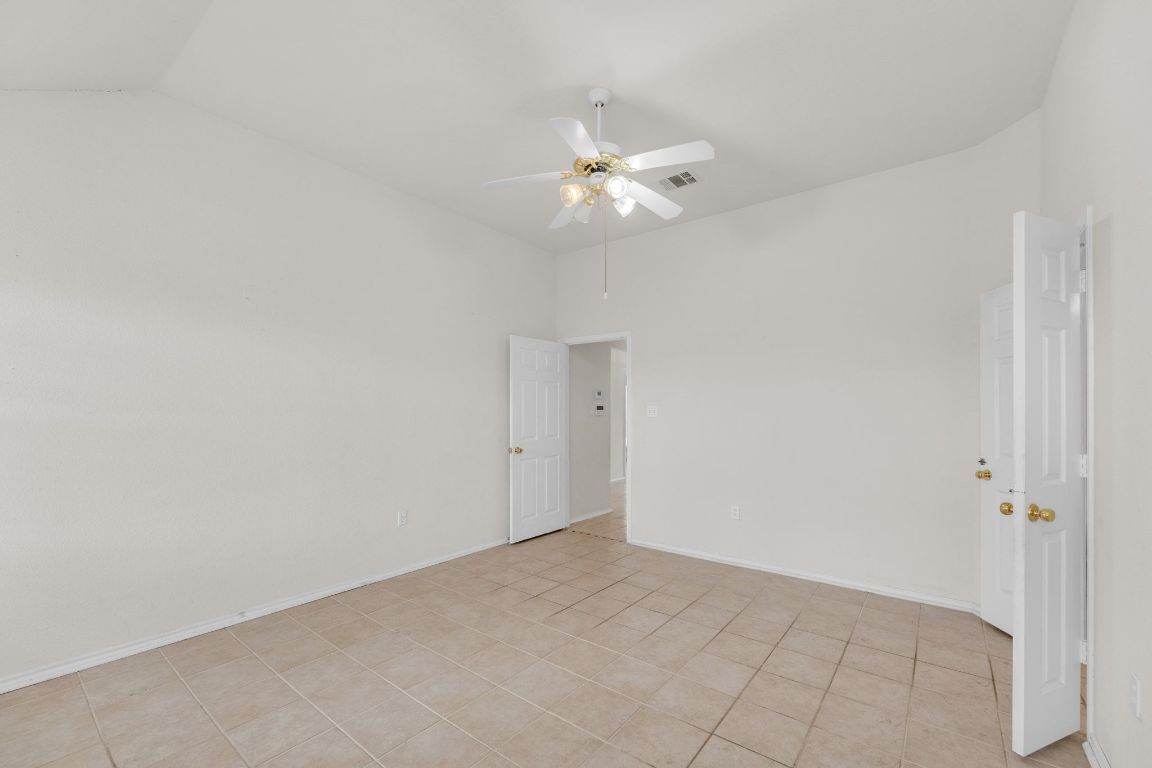 2317 Chestnut Path Round Rock, TX 78664 - Photo 20 of 36 Unfurnished room with light tile patterned floors, vaulted ceiling, and ceiling fan