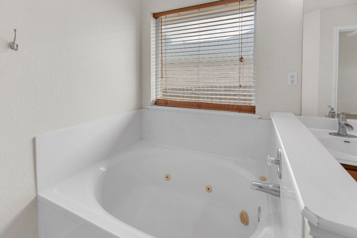 2317 Chestnut Path Round Rock, TX 78664 - Photo 23 of 36 Bathroom with a tub with jets, vanity, and a textured wall