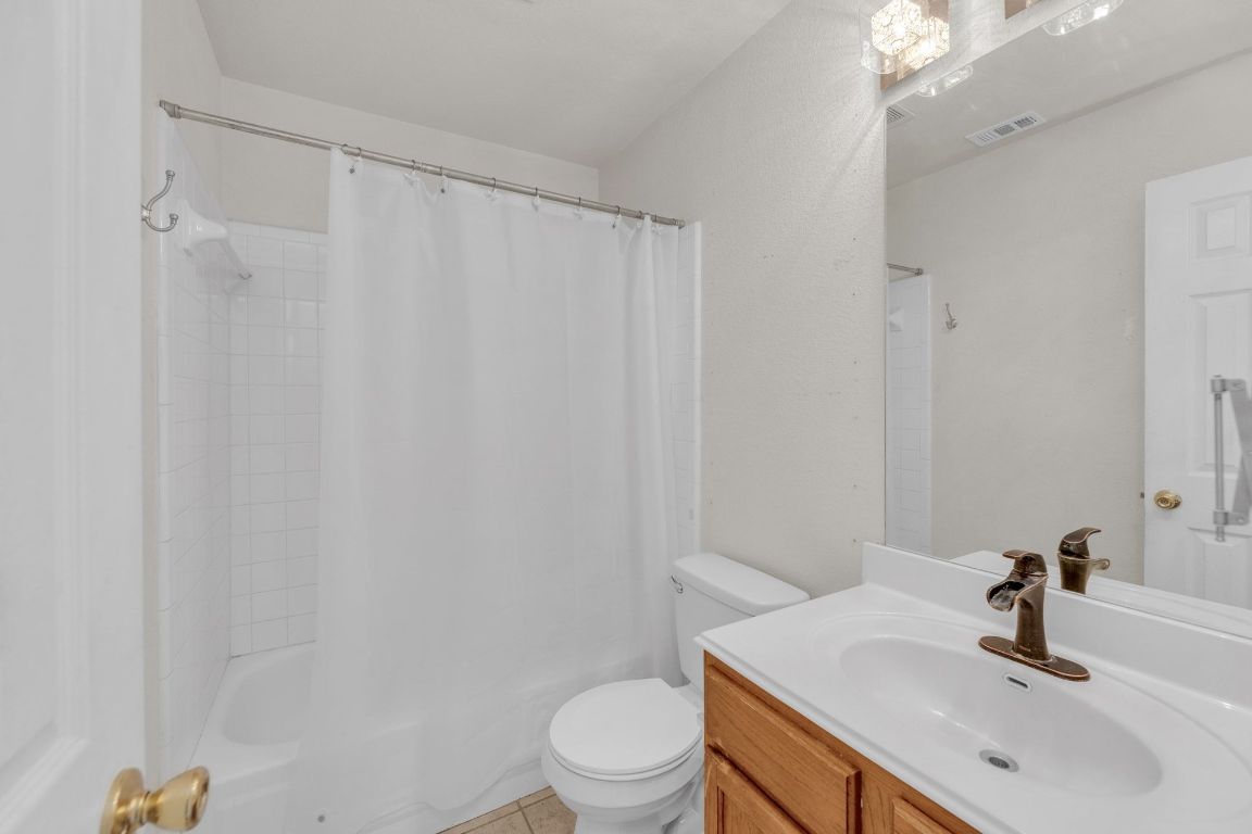 2317 Chestnut Path Round Rock, TX 78664 - Photo 27 of 36 Full bathroom featuring vanity, shower / bathtub combination with curtain, and light tile patterned floors