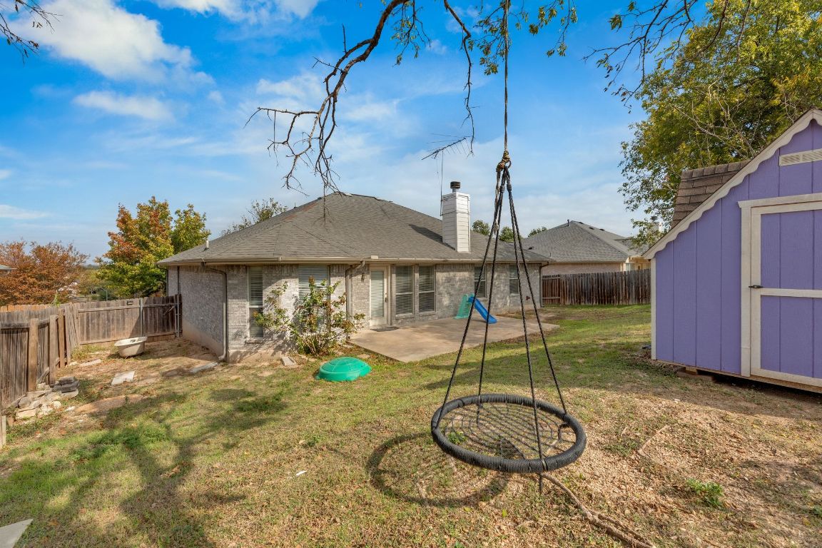 2317 Chestnut Path Round Rock, TX 78664 - Photo 34 of 36 Back of house featuring a fenced backyard, a storage unit, a patio area, a chimney, and brick siding