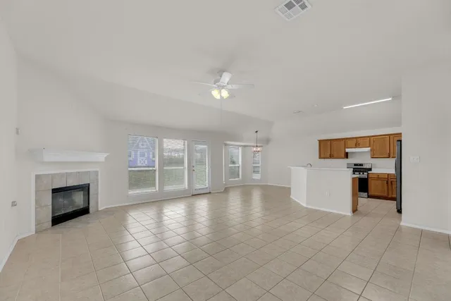 an empty room with windows and fireplace