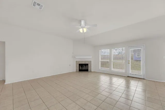 an empty room with windows and fireplace