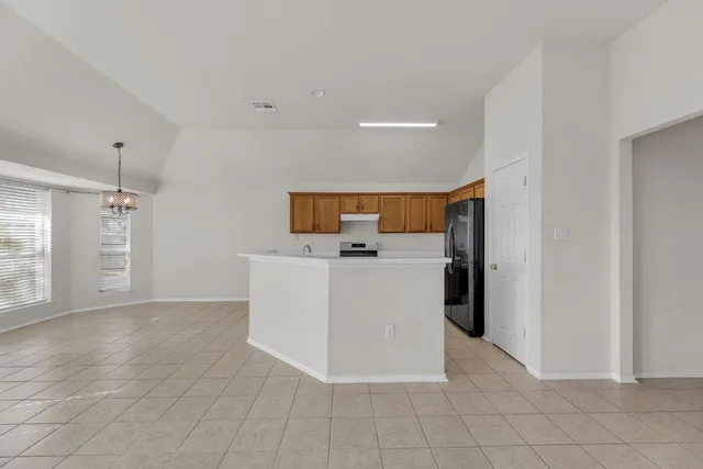 a view of a kitchen with furniture and an empty room