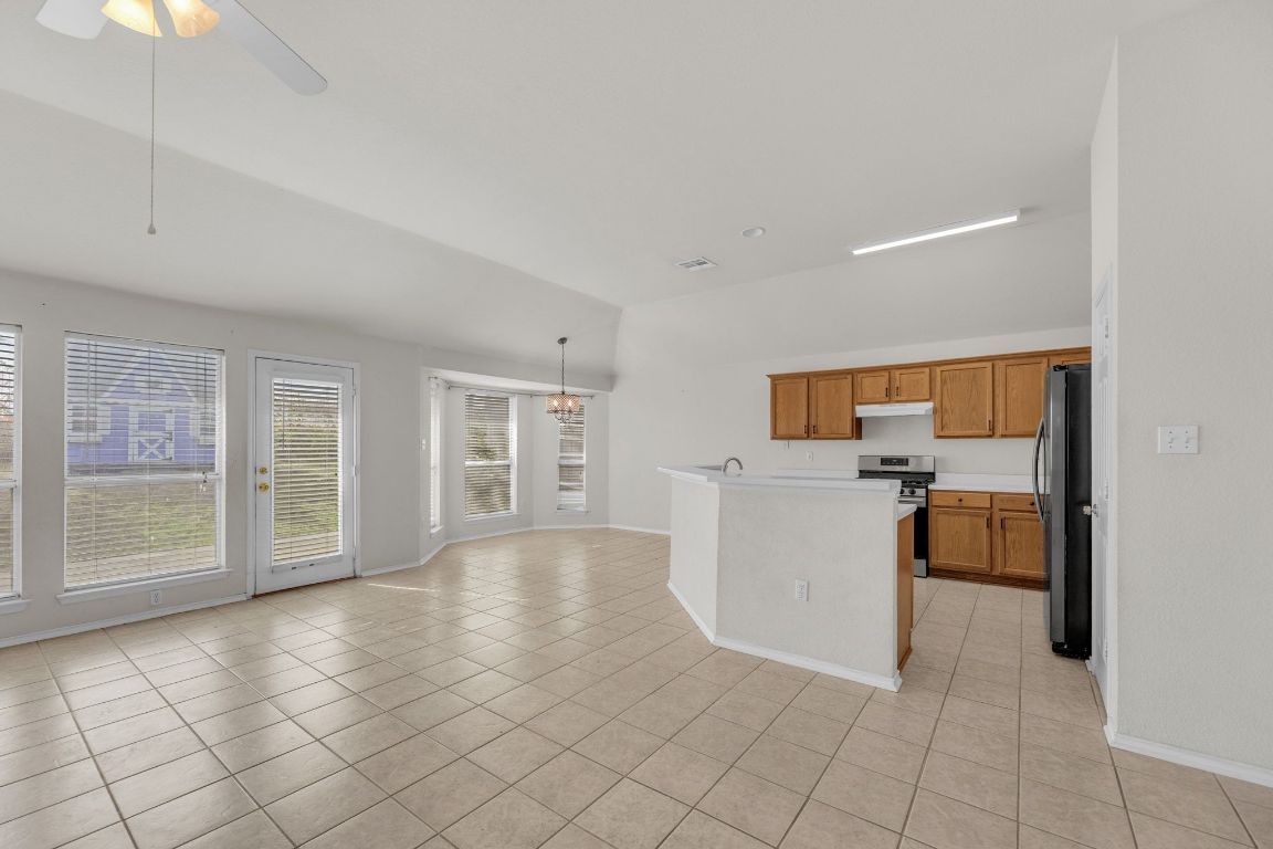 2317 Chestnut Path Round Rock, TX 78664 - Photo 10 of 36 Kitchen with light countertops, brown cabinetry, stainless steel appliances, and light tile patterned floors