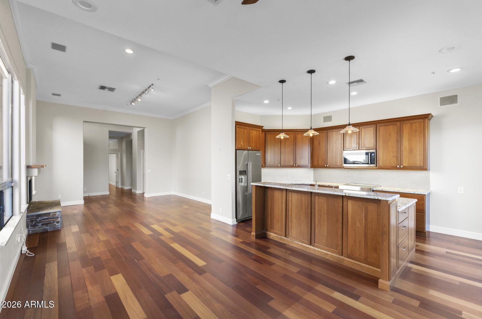 a large kitchen with stainless steel appliances granite countertop a lot of counter space and wooden floors