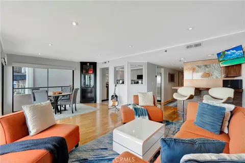 a living room with furniture large windows and view of living room