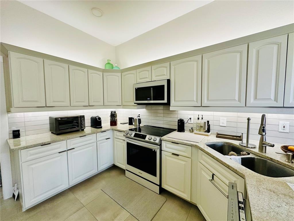 784 South Pennsylvania Avenue Winter Park, FL 32789 - Photo 10 of 29 a kitchen with white cabinets stainless steel appliances and sink