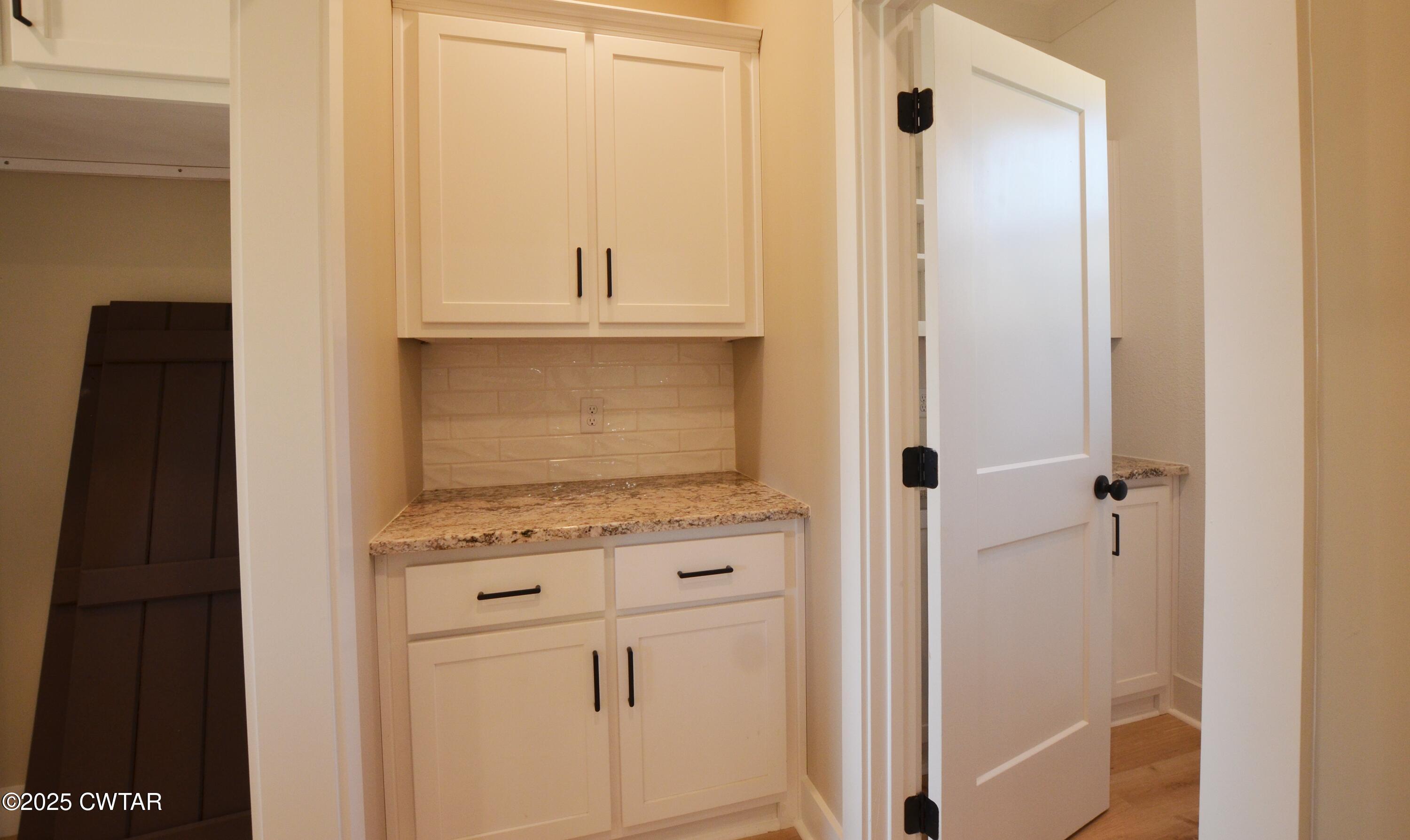 297 Marlow Cemetery Road Gadsden, TN 38337 - Photo 13 of 28 a view of a kitchen with white cabinets and a wooden floor