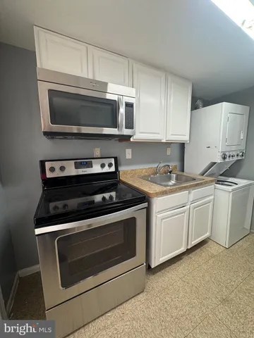 a kitchen with granite countertop a stove microwave and sink