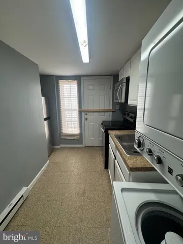 a kitchen that has a sink a stove and a wooden floor
