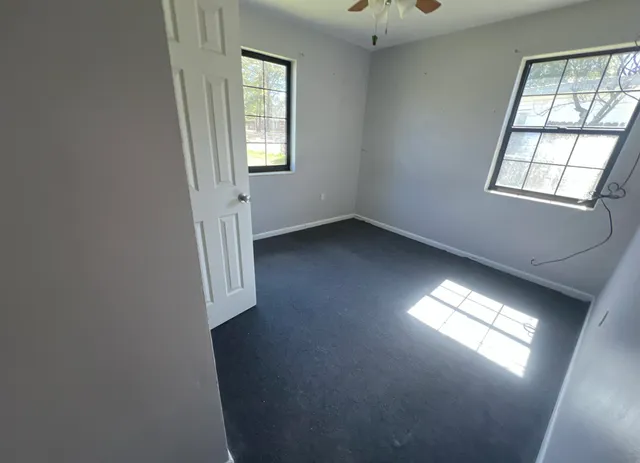 an empty room with windows and closet