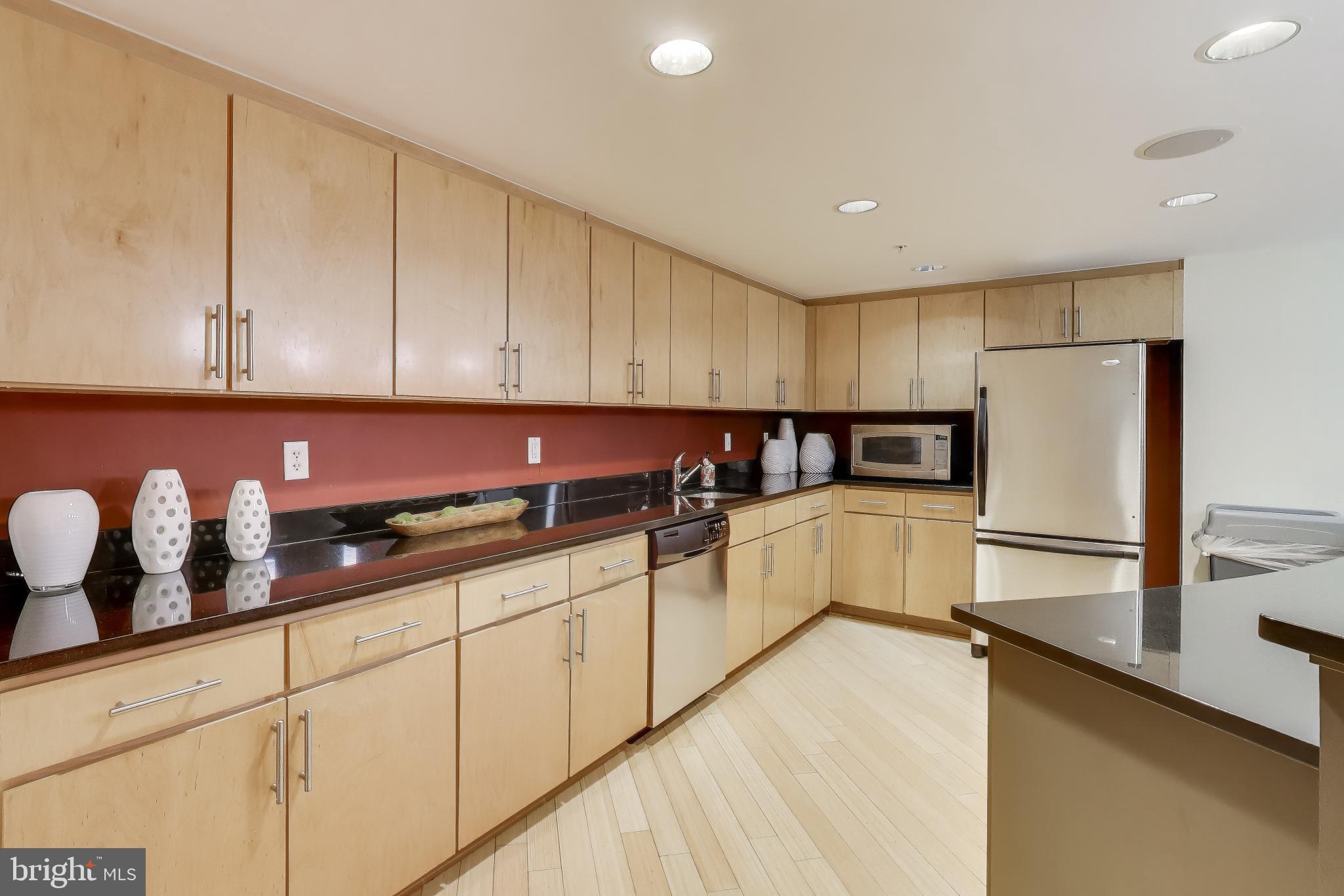 915 E Street Northwest, Unit 414 Washington, DC 20004 - Photo 26 of 35 a kitchen with granite countertop white cabinets and stainless steel appliances