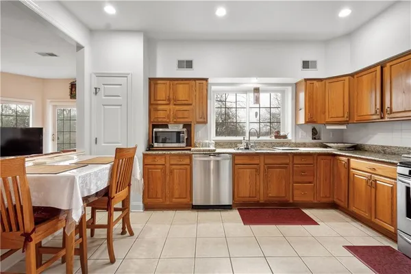 a kitchen with stainless steel appliances granite countertop a refrigerator and a stove top oven